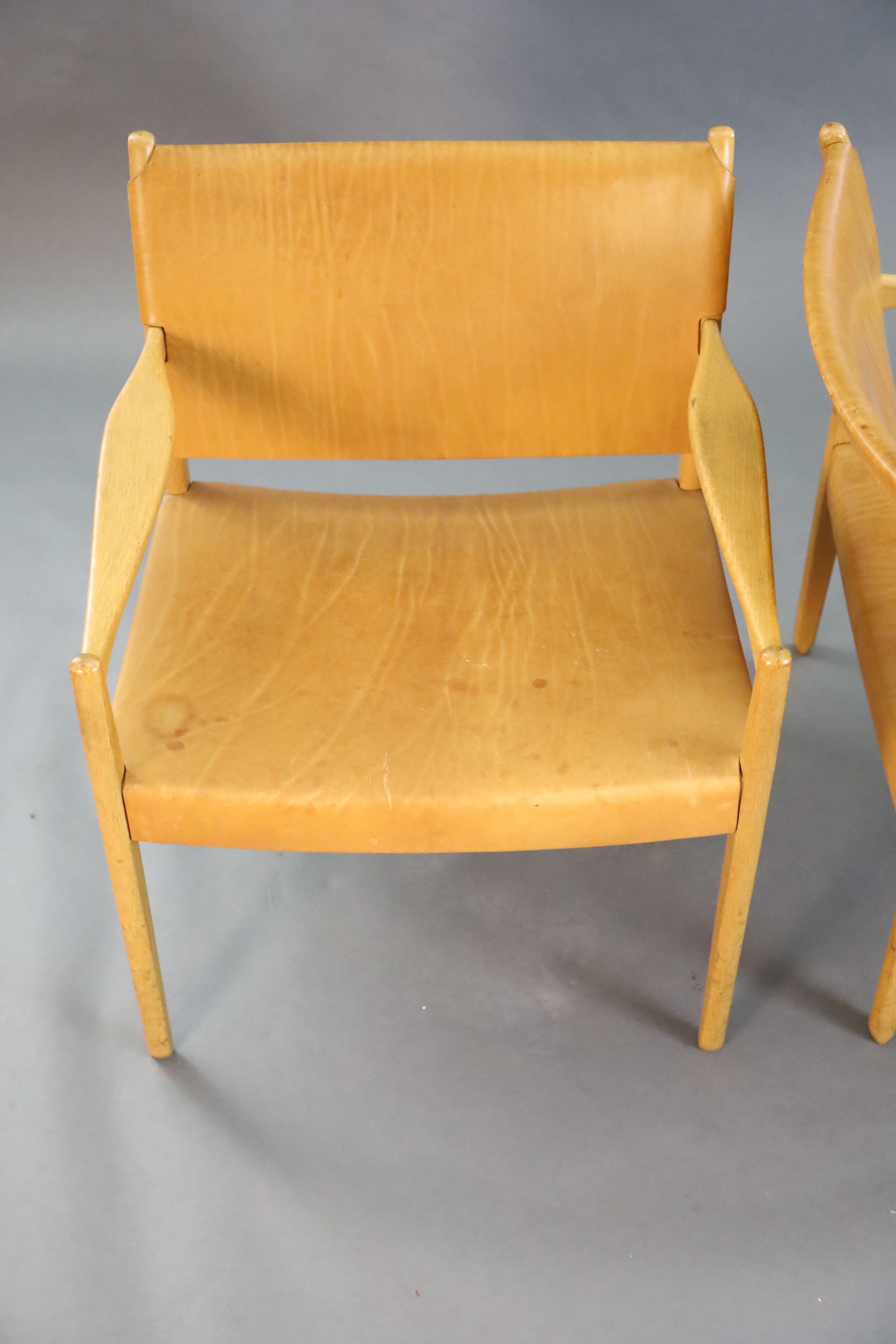 A pair of Swedish Varufakta tan leather and golden oak armchairs, W.2ft 1in. D. 2ft 1in. H.2ft 4in.